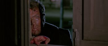 Movie still from “A Fistful of Dollars” (1964), directed by Sergio Leone – A person with blood all over his face; Close Up shot, Over the shoulder angle