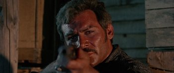 Movie still from “A Fistful of Dollars” (1964), directed by Sergio Leone – A person holding a gun in a room; Close Up shot, Low angle