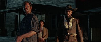 Movie still from “A Fistful of Dollars” (1964), directed by Sergio Leone – A group of men standing next to each other on a field; Medium shot, Low angle