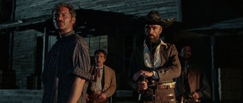Movie still from “A Fistful of Dollars” (1964), directed by Sergio Leone – A group of men standing next to each other; Medium shot, Low angle