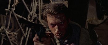 Movie still from “A Fistful of Dollars” (1964), directed by Sergio Leone – A person holding a gun in a room; Close Up shot, Low angle