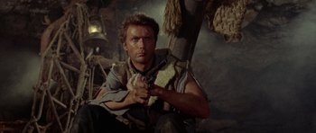 Movie still from “A Fistful of Dollars” (1964), directed by Sergio Leone – A person holding a gun in a room; Close Up shot, Low angle