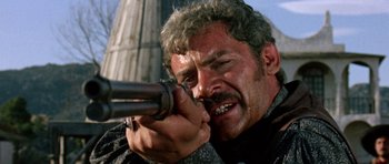Movie still from “A Fistful of Dollars” (1964), directed by Sergio Leone – A person with a gun; Close Up shot, Low angle