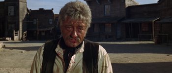 Movie still from “A Fistful of Dollars” (1964), directed by Sergio Leone – A person with blood all over his face; Close Up shot, Low angle