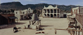 Movie still from “A Fistful of Dollars” (1964), directed by Sergio Leone – Two men laying on the ground in a deserted town; Extreme Wide shot, High angle