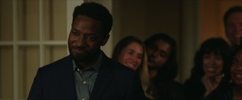 Movie still from “A Good Person” (2023), directed by Zach Braff – A man standing next to two women in a room; Close Up shot, Over the shoulder angle