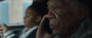 Movie still from “A Good Person” (2023), directed by Zach Braff – An older man talking on a cell phone; Close Up shot, Over the shoulder angle