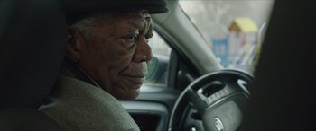 Movie still from “A Good Person” (2023), directed by Zach Braff – An older man sitting in a car looking out the window; Close Up shot, Low angle