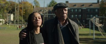 Movie still from “A Good Person” (2023), directed by Zach Braff – An older man and a young woman standing next to each other; Medium shot, Over the shoulder angle