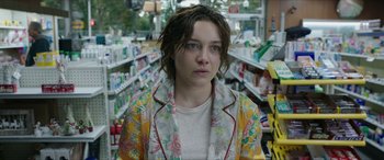 Movie still from “A Good Person” (2023), directed by Zach Braff – A woman in a floral jacket in a store; Close Up shot, Over the shoulder angle