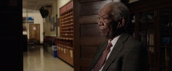 Movie still from “A Good Person” (2023), directed by Zach Braff – An older man wearing a suit and tie in a room; Close Up shot, Low angle