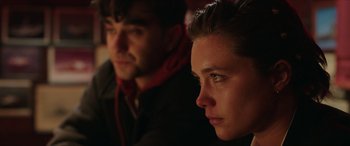 Movie still from “A Good Person” (2023), directed by Zach Braff – A man and a woman sitting next to each other in the dark; Close Up shot, Over the shoulder angle