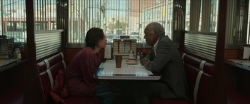 Movie still from “A Good Person” (2023), directed by Zach Braff – A man and a woman sitting at a table in front of a window; Medium shot, Over the shoulder angle