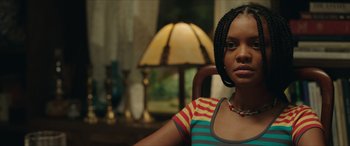 Movie still from “A Good Person” (2023), directed by Zach Braff – A woman sitting in a chair in front of a lamp; Close Up shot, Over the shoulder angle