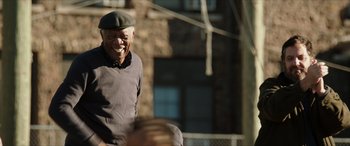 Movie still from “A Good Person” (2023), directed by Zach Braff – An older man wearing a hat and smiling; Medium shot, Low angle