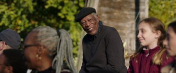 Movie still from “A Good Person” (2023), directed by Zach Braff – An older man wearing a black hat and sweater; Close Up shot, Over the shoulder angle