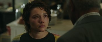 Movie still from “A Good Person” (2023), directed by Zach Braff – A young woman looking sad while talking to a man; Close Up shot, Over the shoulder angle