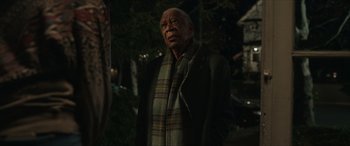 Movie still from “A Good Person” (2023), directed by Zach Braff – An older man wearing a scarf and a jacket; Medium shot, Over the shoulder angle
