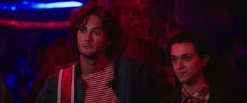 Movie still from “A Good Person” (2023), directed by Zach Braff – A man and a woman are standing in front of a crowd; Close Up shot, Low angle