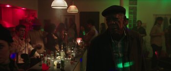 Movie still from “A Good Person” (2023), directed by Zach Braff – A group of people sitting at a bar with drinks on the table; Medium shot, Over the shoulder angle