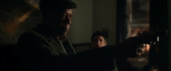 Movie still from “A Good Person” (2023), directed by Zach Braff – An older man wearing a hat and a jacket; Close Up shot, Over the shoulder angle