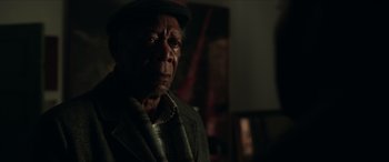 Movie still from “A Good Person” (2023), directed by Zach Braff – An older man wearing a hat and a jacket; Close Up shot, Over the shoulder angle