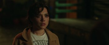 Movie still from “A Good Person” (2023), directed by Zach Braff – A young woman with brown hair wearing a white t - shirt; Close Up shot, Over the shoulder angle