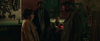 Movie still from “A Good Person” (2023), directed by Zach Braff – A group of people standing in front of a green door; Medium shot, Over the shoulder angle