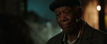 Movie still from “A Good Person” (2023), directed by Zach Braff – An older man wearing a hat and a jacket; Close Up shot, Over the shoulder angle