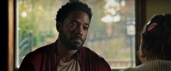 Movie still from “A Good Person” (2023), directed by Zach Braff – A person wearing a jacket; Close Up shot, Over the shoulder angle