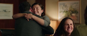 Movie still from “A Good Person” (2023), directed by Zach Braff – A woman is hugging a man in a room; Medium shot, Over the shoulder angle