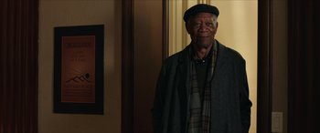 Movie still from “A Good Person” (2023), directed by Zach Braff – An older man wearing a hat and a scarf; Medium shot, Over the shoulder angle