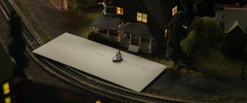 Movie still from “A Good Person” (2023), directed by Zach Braff – A model of a house and a train track; Extreme Wide shot, High angle