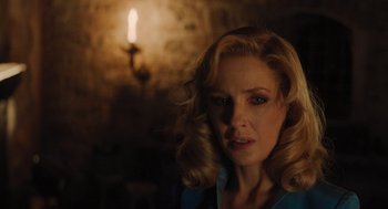 Movie still from “A Haunting in Venice” (2023), directed by Kenneth Branagh – A woman with blonde hair is looking at the camera; Close Up shot, Over the shoulder angle