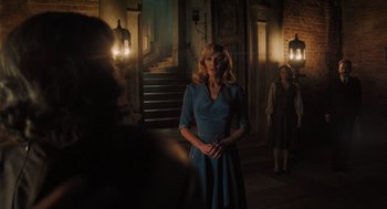 Movie still from “A Haunting in Venice” (2023), directed by Kenneth Branagh – A woman in a blue dress standing in front of two other women; Wide shot, Low angle
