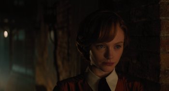 Movie still from “A Haunting in Venice” (2023), directed by Kenneth Branagh – A woman with red hair wearing a red shirt; Close Up shot, Over the shoulder angle