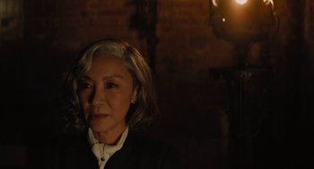 Movie still from “A Haunting in Venice” (2023), directed by Kenneth Branagh – A woman with short blonde hair wearing a white shirt; Close Up shot, Over the shoulder angle