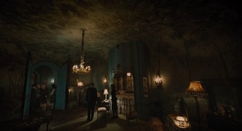 Movie still from “A Haunting in Venice” (2023), directed by Kenneth Branagh – Two people standing in a dark room with a bed and a table; Extreme Wide shot, Overhead angle