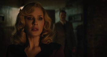Movie still from “A Haunting in Venice” (2023), directed by Kenneth Branagh – A woman with blonde hair standing next to a man; Close Up shot, Low angle