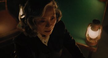 Movie still from “A Haunting in Venice” (2023), directed by Kenneth Branagh – A woman in a black suit looking down at her face; Close Up shot, Low angle