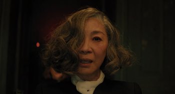 Movie still from “A Haunting in Venice” (2023), directed by Kenneth Branagh – A person wearing a suit and tie; Close Up shot, Low angle