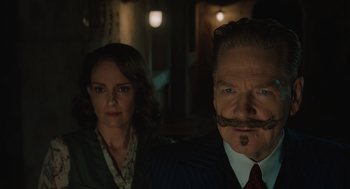 Movie still from “A Haunting in Venice” (2023), directed by Kenneth Branagh – A man and a woman are posing for a picture; Close Up shot, Low angle
