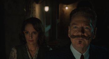 Movie still from “A Haunting in Venice” (2023), directed by Kenneth Branagh – A man and a woman standing next to each other in a dark room; Close Up shot, Low angle