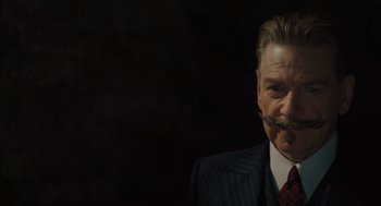 Movie still from “A Haunting in Venice” (2023), directed by Kenneth Branagh – An older man in a suit with a mustache; Close Up shot, Low angle