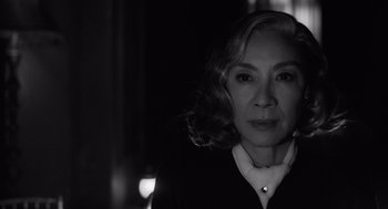Movie still from “A Haunting in Venice” (2023), directed by Kenneth Branagh – Black and white photograph of a woman in a dark room; Close Up shot, Low angle
