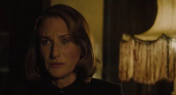 Movie still from “A Haunting in Venice” (2023), directed by Kenneth Branagh – A person wearing a black shirt; Close Up shot, Over the shoulder angle