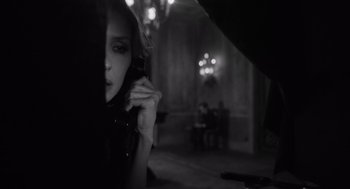 Movie still from “A Haunting in Venice” (2023), directed by Kenneth Branagh – A woman holding a cell phone up to her ear; Close Up shot, Over the shoulder angle