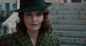 Movie still from “A Haunting in Venice” (2023), directed by Kenneth Branagh – A person wearing a suit and a hat; Close Up shot, Low angle