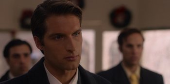 Movie still from “A Hollywood Christmas” (2022), directed by Alex Ranarivelo – A person wearing a suit and tie; Close Up shot, Over the shoulder angle