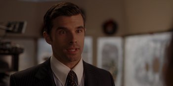 Movie still from “A Hollywood Christmas” (2022), directed by Alex Ranarivelo – A person wearing a suit and tie; Close Up shot, Over the shoulder angle